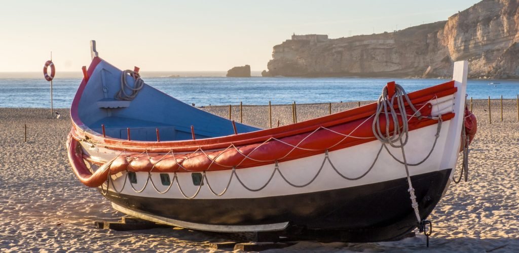 A fishing boat on the beach of Nazare in Portugal during daytime